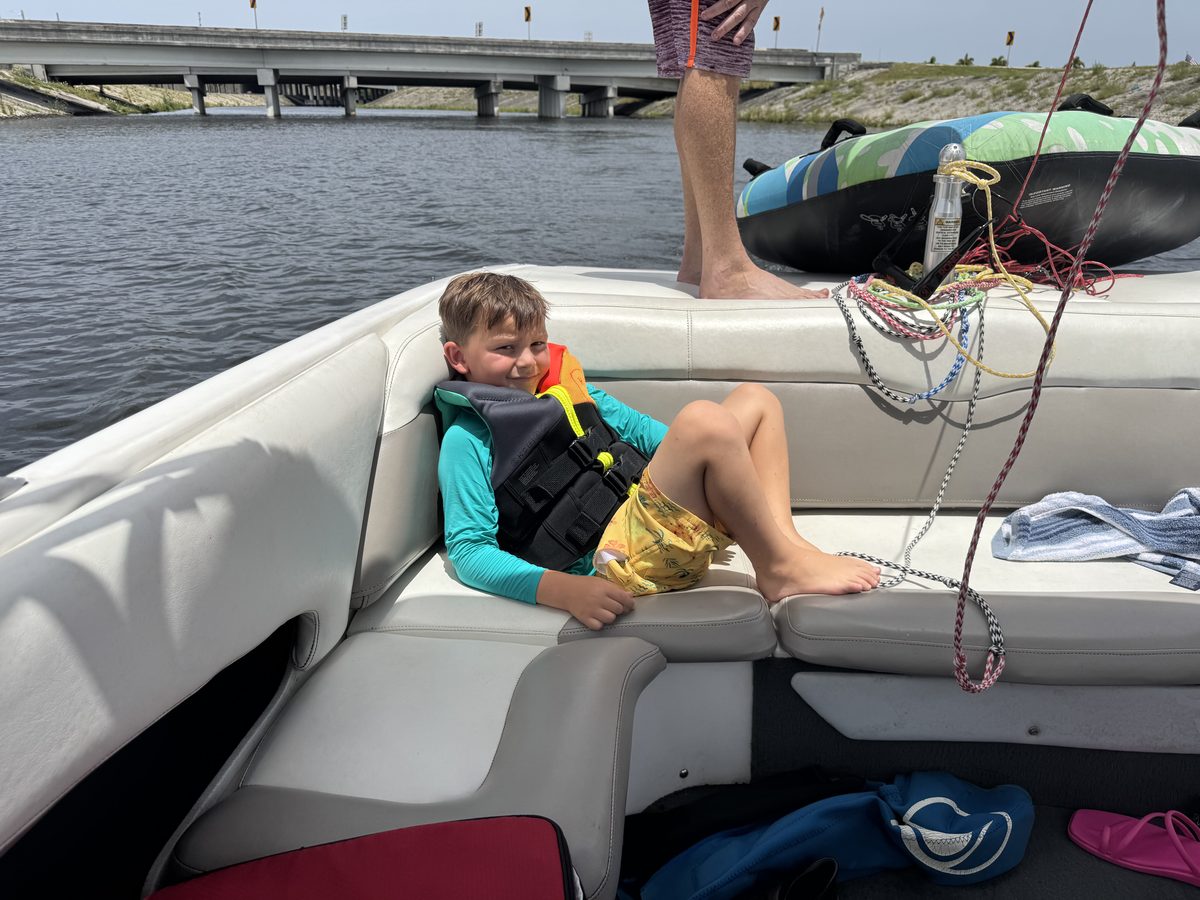 A young rider relaxing in a life vest aboard the charter boat